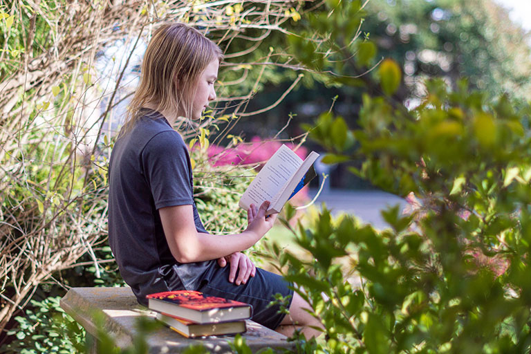 Girl reading books Girl sitting on stone bench and reading books